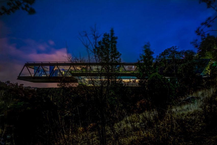 One-storey cantilevering structure on a sloping site at night