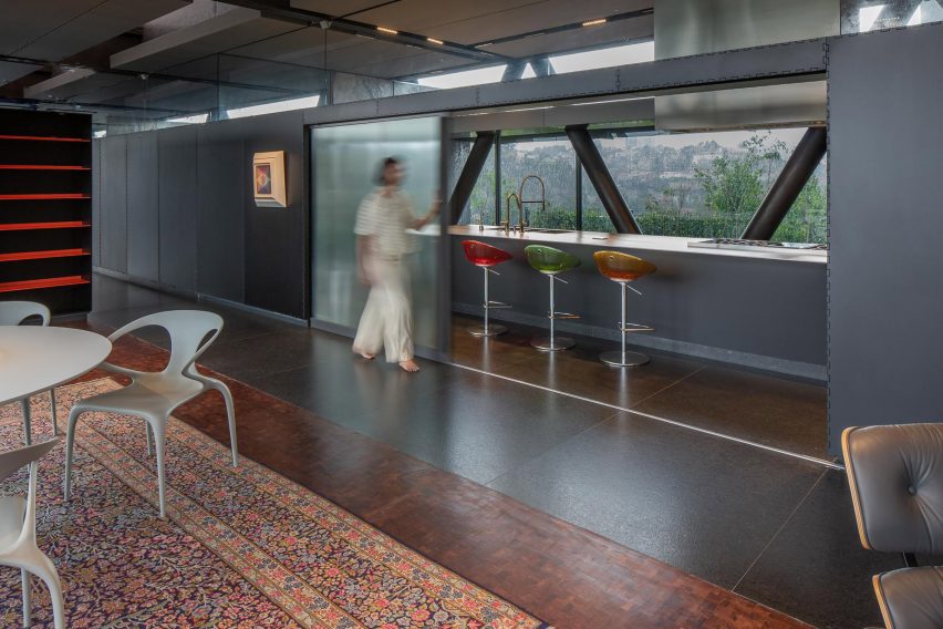 Open-plan living space with granite floors and sliding grey doors that separates the kitchen