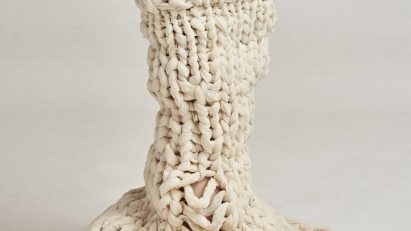 Photograph of model wearing neutral-coloured unravelling garment