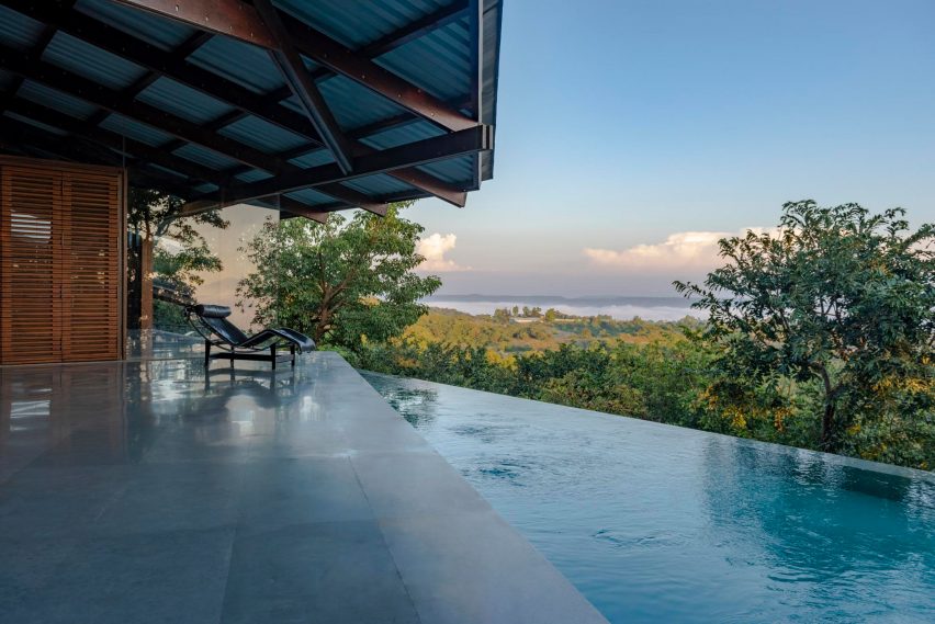 Outdoor terrace with an infinity swimming pool and metal roof with a timber structure