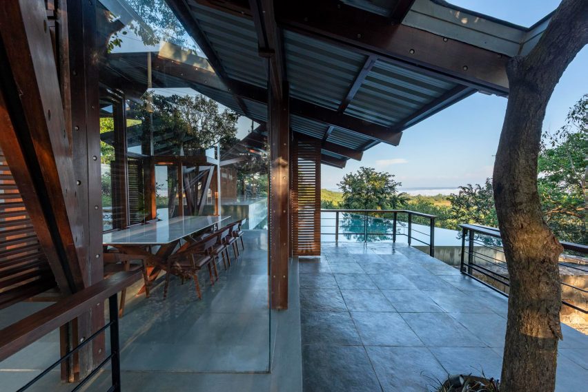 Outdoor terrace with a swimming pool and angular roof with a timber structure