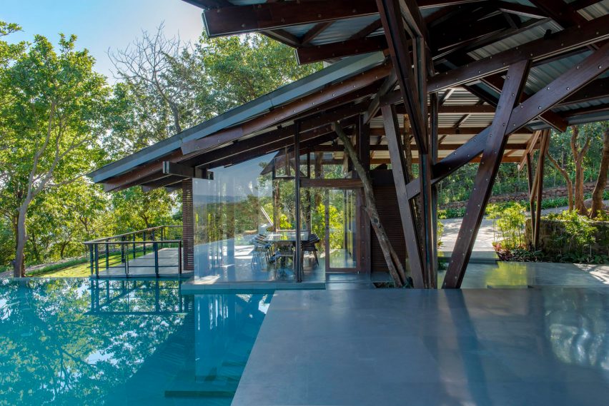Outdoor terrace with a swimming pool and angular roof with a timber structure