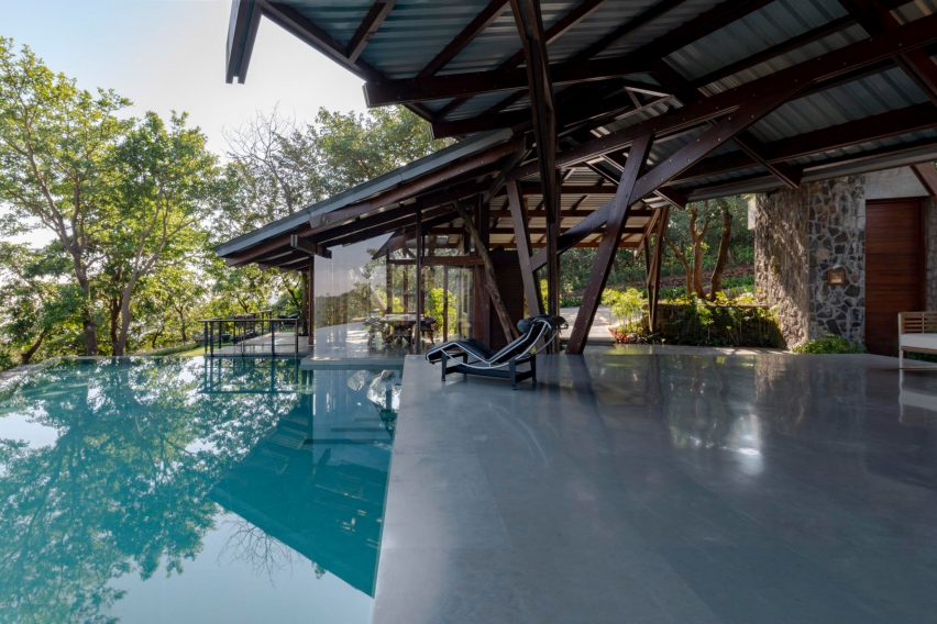 Outdoor terrace with a swimming pool and angular roof with a timber structure