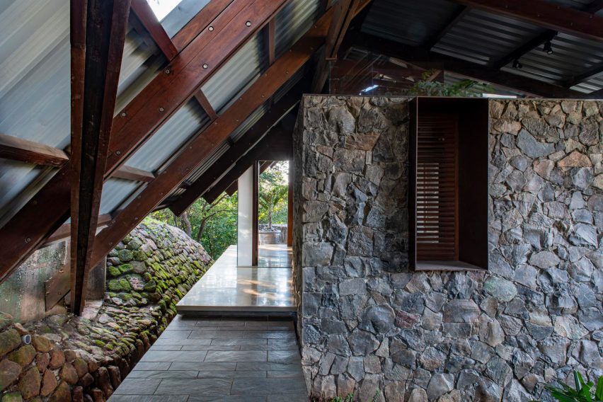 A home with stone walls and metal pitched roof with a wood structure