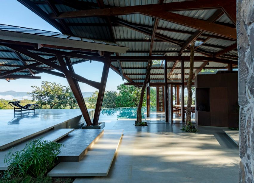 Outdoor terrace with a swimming pool and angular roof with a timber structure