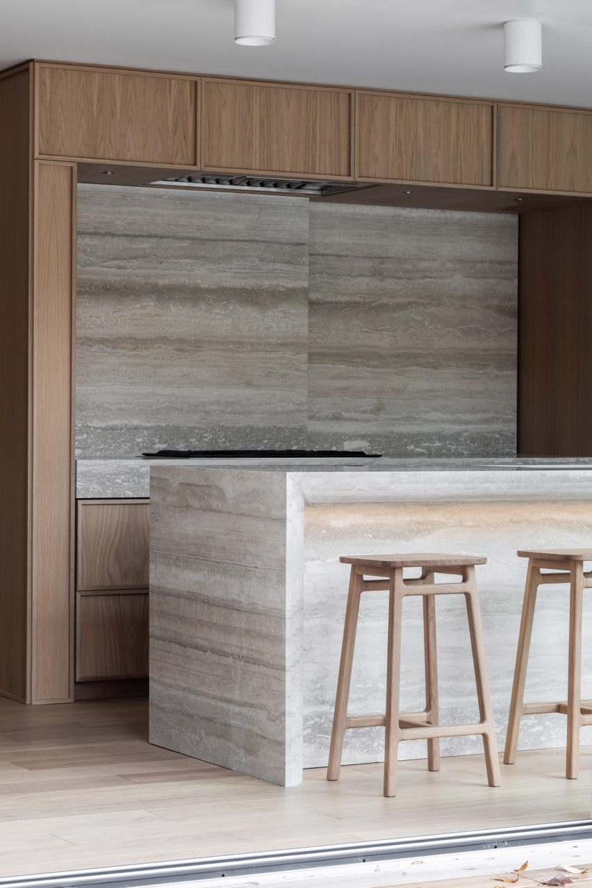 Travertine stone kitchen island and backsplash with oak cabinets