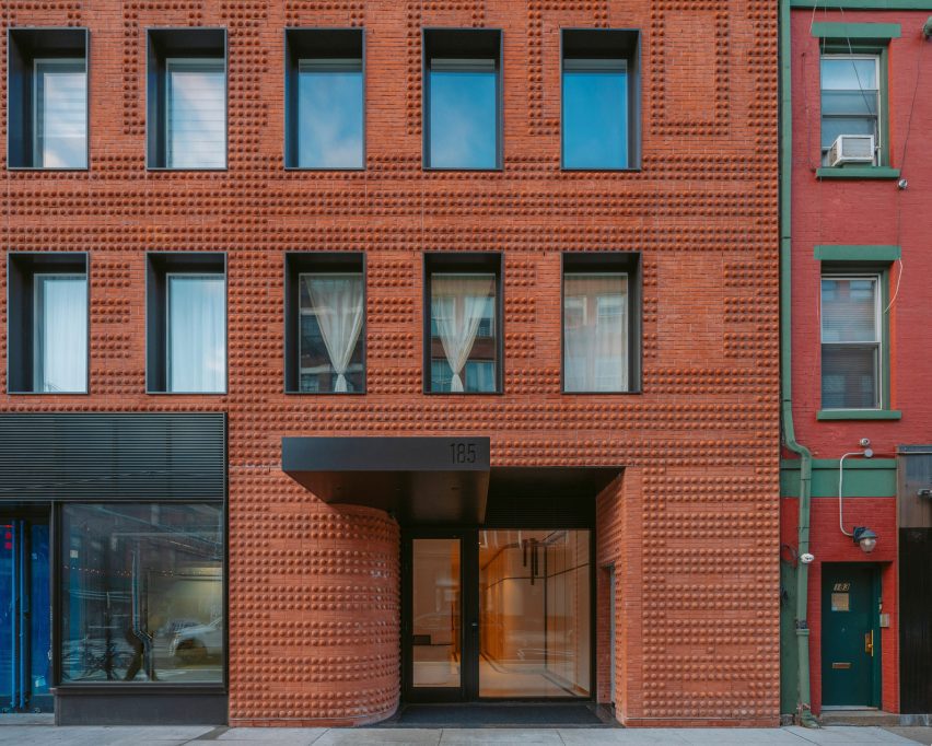 Exterior of the entrance lobby to the red-brick Grand Mulburry building by Morris Adjmi