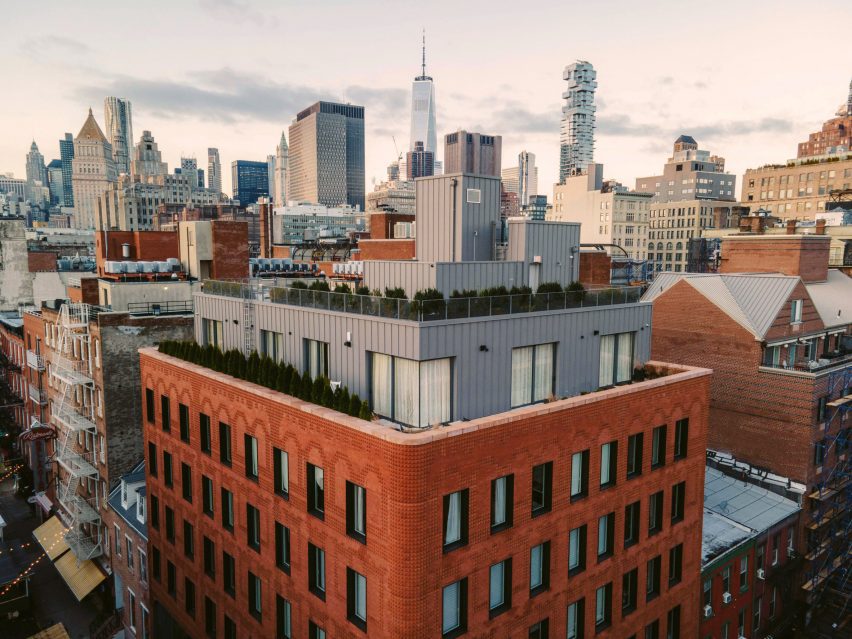 Exterior of the red-brick Grand Mulburry building by Morris Adjmi with a textured facade on a New York street corner