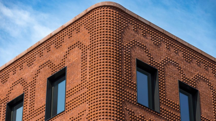 Exterior corner of the red-brick Grand Mulburry building by Morris Adjmi with a textured facade