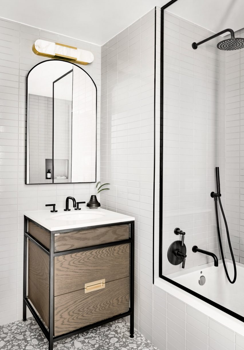 Bathroom with a wood vanity, decorative tiled floors and white walls