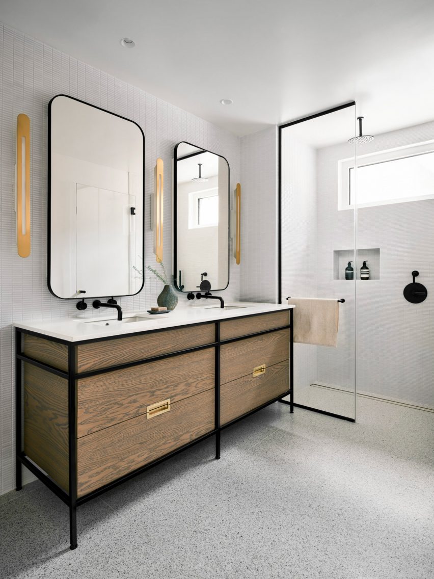 White bathroom with a wooden double vanity and walk-in shower