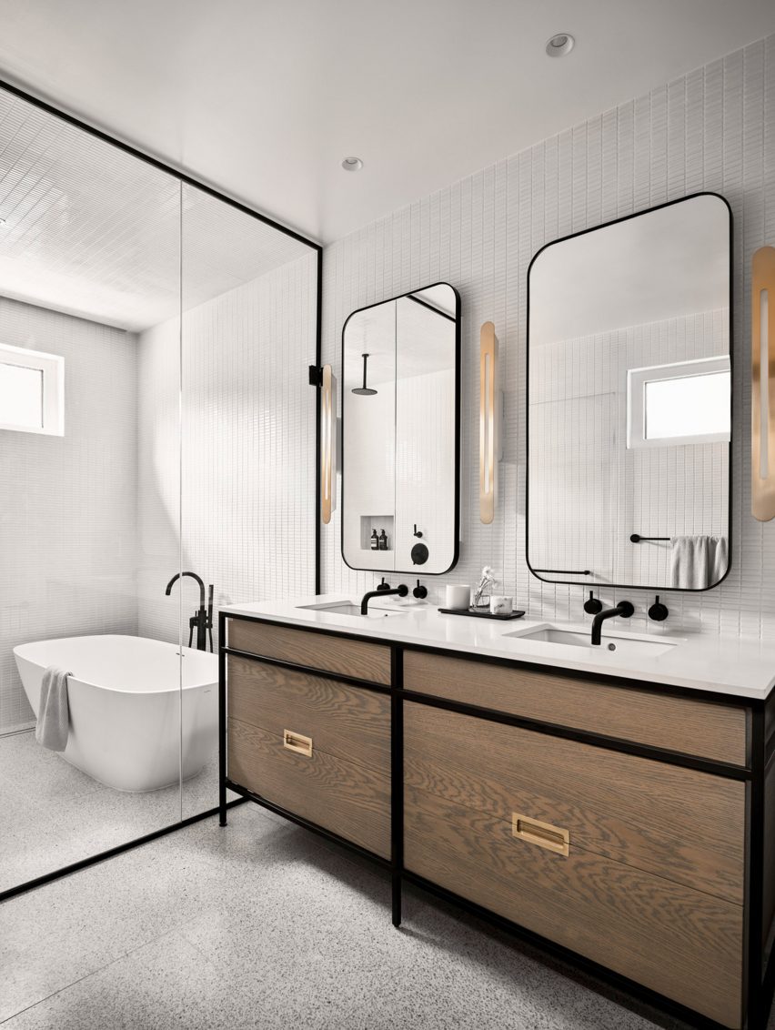 White bathroom with a wooden double vanity and walk-in wet room