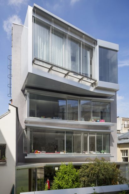 A multi-storey building with glazed walls and floor levels jutting at different angles