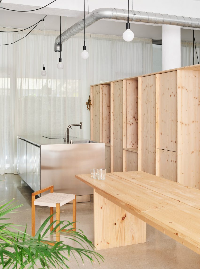 Interior of the open-plan kitchen at NZ10 Apartment in Spain by Auba Studio with wood cabinets