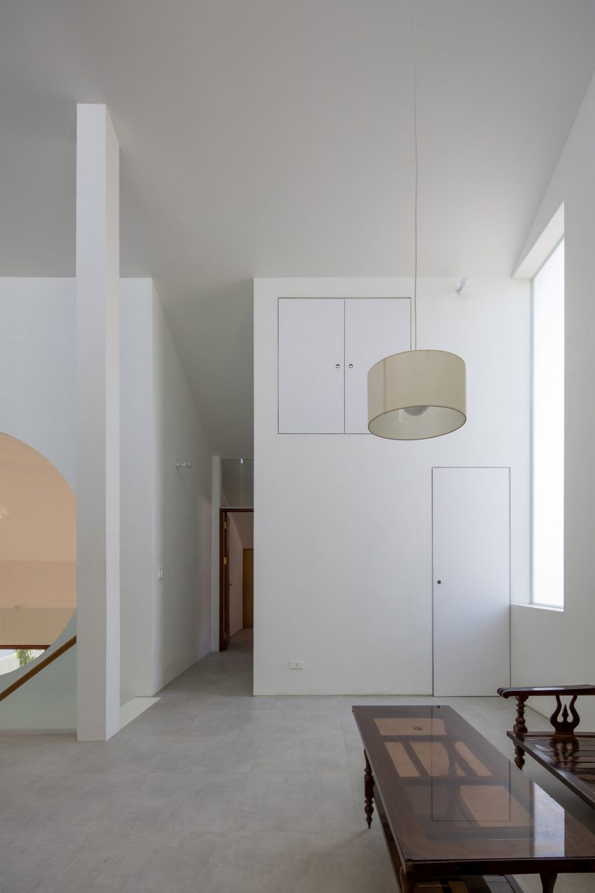 Interior space with concrete floors, white walls and white pendant light