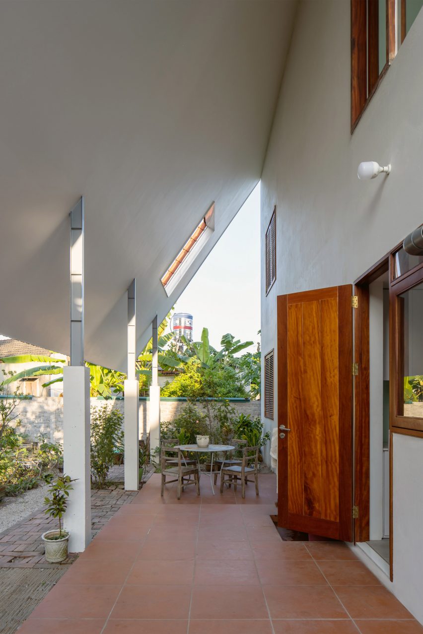 Outdoor porch with terracotta flooring and slanted white roof overhead