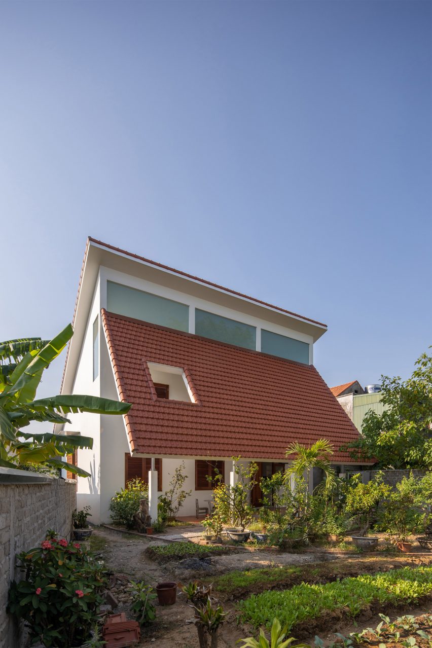 Exterior of a house in Vietnam with a terracotta-tiled roof and planted garden