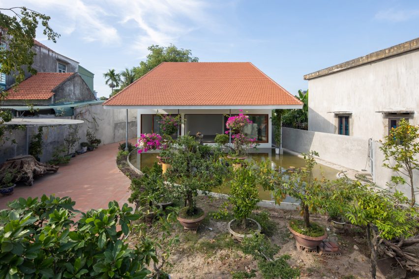 Exterior of a house in Vietnam with a terracotta-tiled roof and planted garden