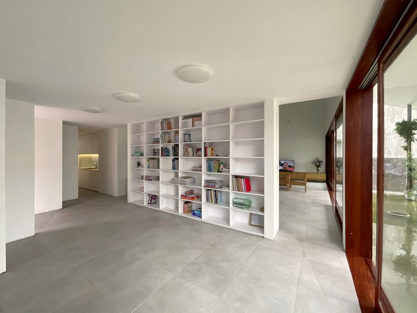Interior space with concrete flooring, white walls and a built-in bookshelf