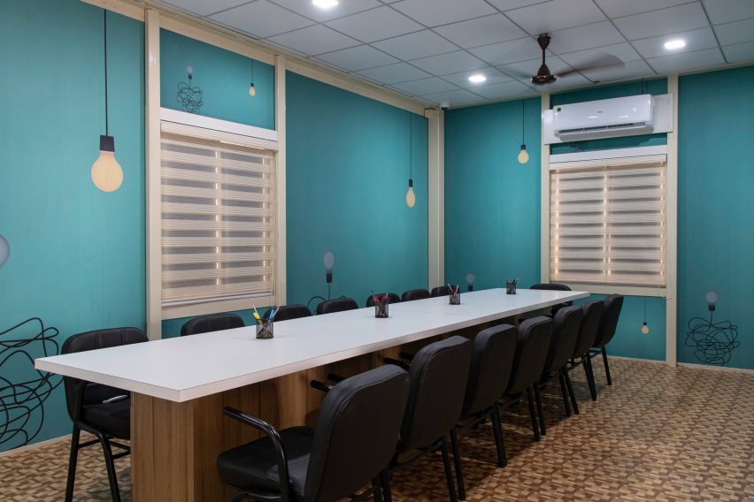 Interior of a classroom with blue walls and a long table and chairs