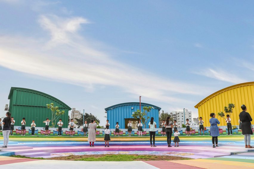 Colourful amphitheatre surrounded by green, blue and yellow steel buildings