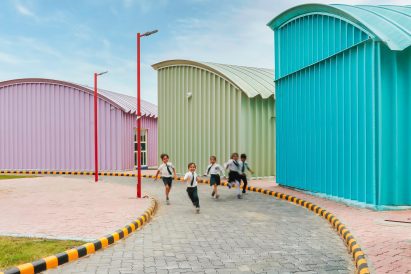 Blue, Green and pink steel structures along a curved pathway with school children playing