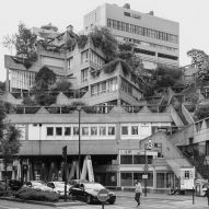 Black and white photo of a brutalist residential and commercial building complex with blocks aligned at different angles