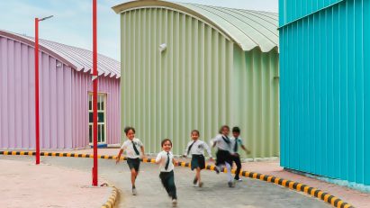 Blue, Green and pink steel structures along a curved pathway with school children playing