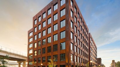 Exterior of the T3 office building with weathered steel cladding and grid windows