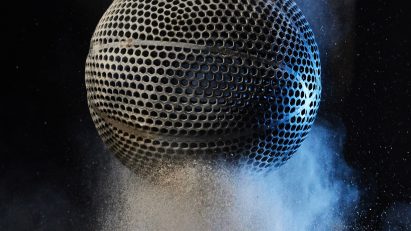Black airless 3D-printed basketball by Wilson bouncing on a powder material