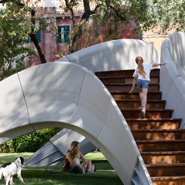 Girl climbing up stairs of Striatus 3D-printed concrete footbridge