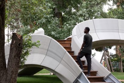 Man climbing up the stairs of Striatus 3D-printed concrete footbridge
