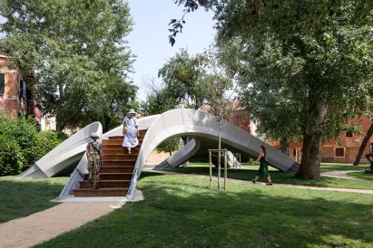 Two women climbing up the stairs of Striatus 3D-printed concrete footbridge