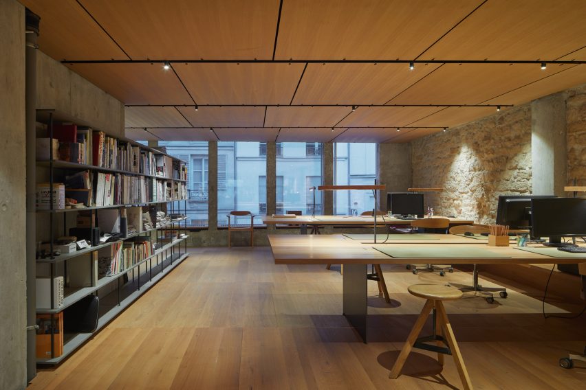 Studio space with wooden flooring, desks, shelves and circular wood swivel seats