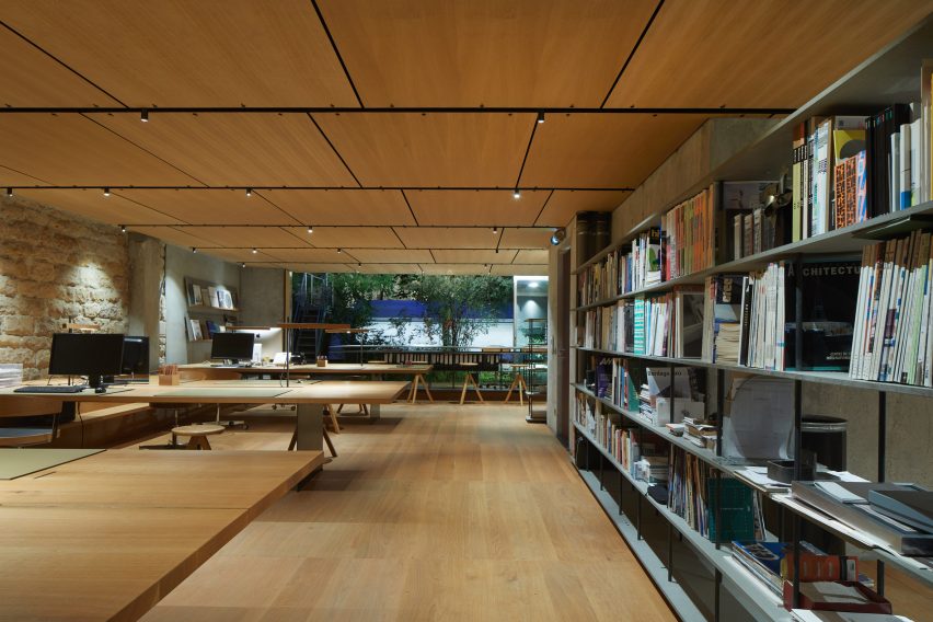 Studio space with wooden flooring, desks, shelves and circular wood swivel seats