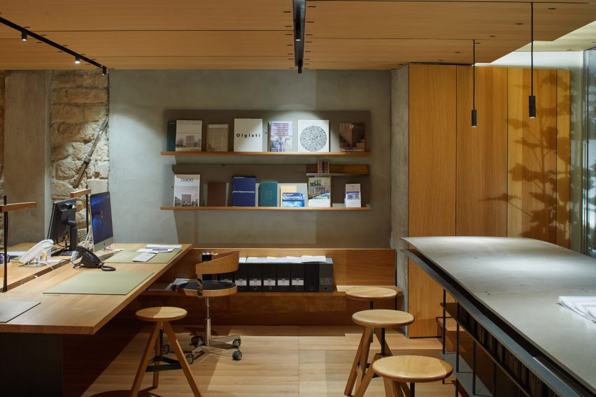 Studio space with wooden flooring, desks, shelves and circular wood swivel seats