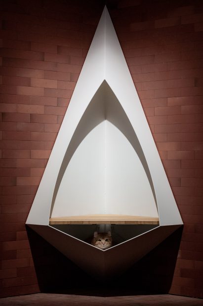 Lit corner of brick corridor with triangular seat inserted