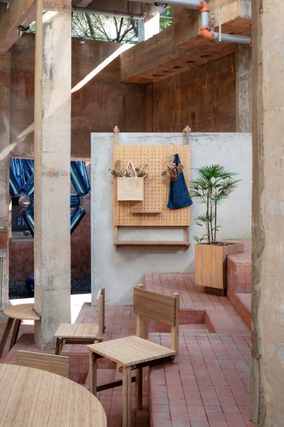 Chairs balanced on step with two front legs with peg notice board hooked over wall
