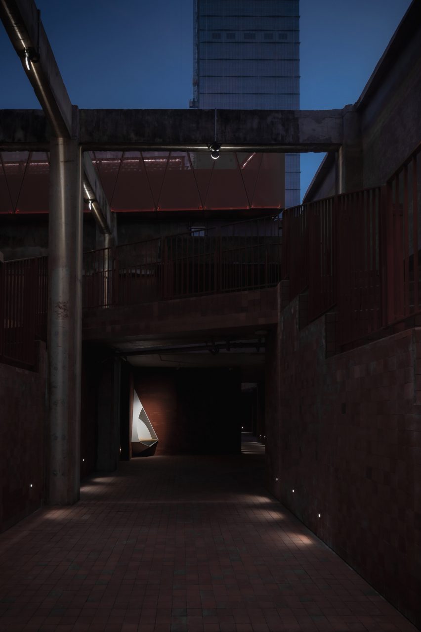 Lit corner of brick corridor with triangular seat inserted