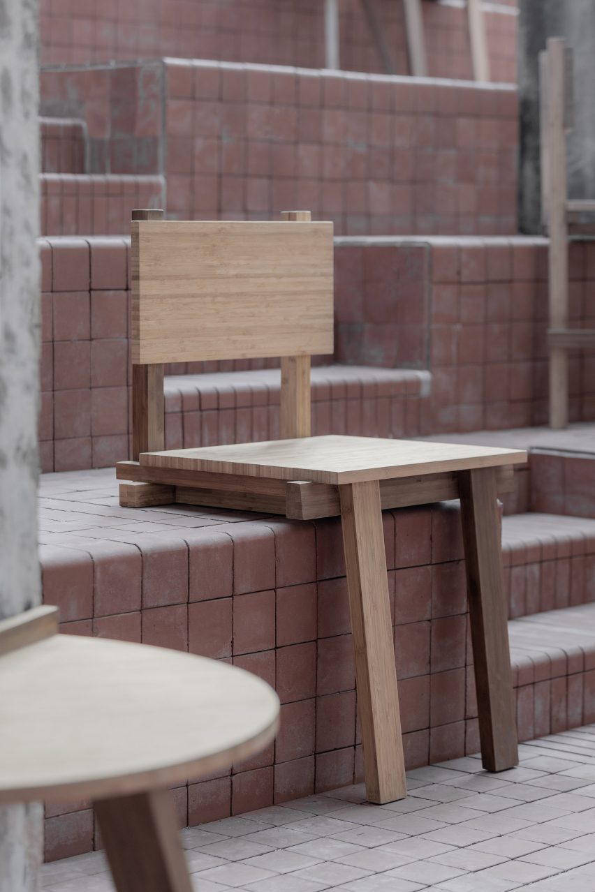 Chair balanced on step with two front legs over edge