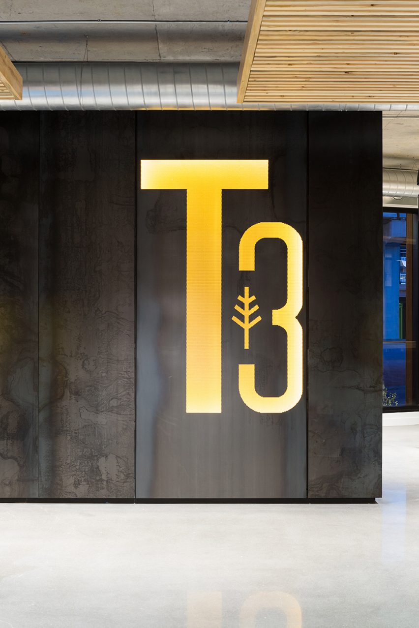 Concrete interior space with a yellow T3 logo on the wall