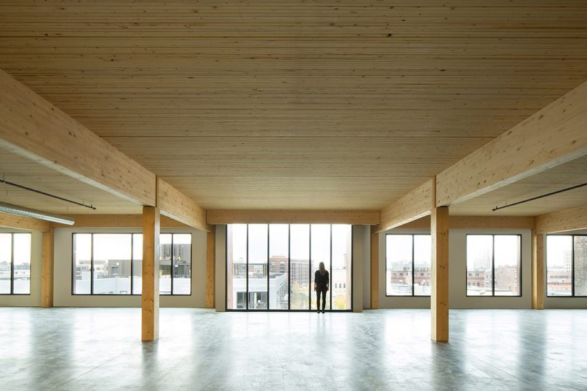 Interior of an empty office space with concrete floor and timber ceiling and structure