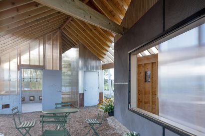 Interior of structure with wooden slats and chairs for gathering