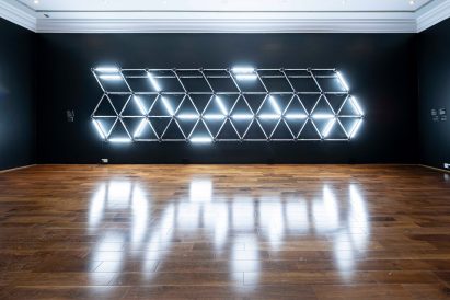 Lighting system mounted onto wall with reflection in polished wood floor