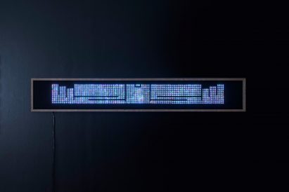 Horizontal, long panel mounted on wall showing sparkly text