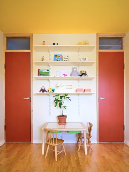 Identical orange doors leading to twins' bedroom in Stockholm apartment