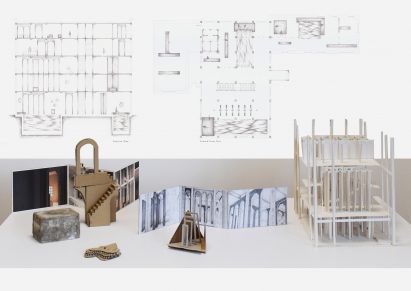 A photograph of a display that includes a model and print-outs with technical drawings