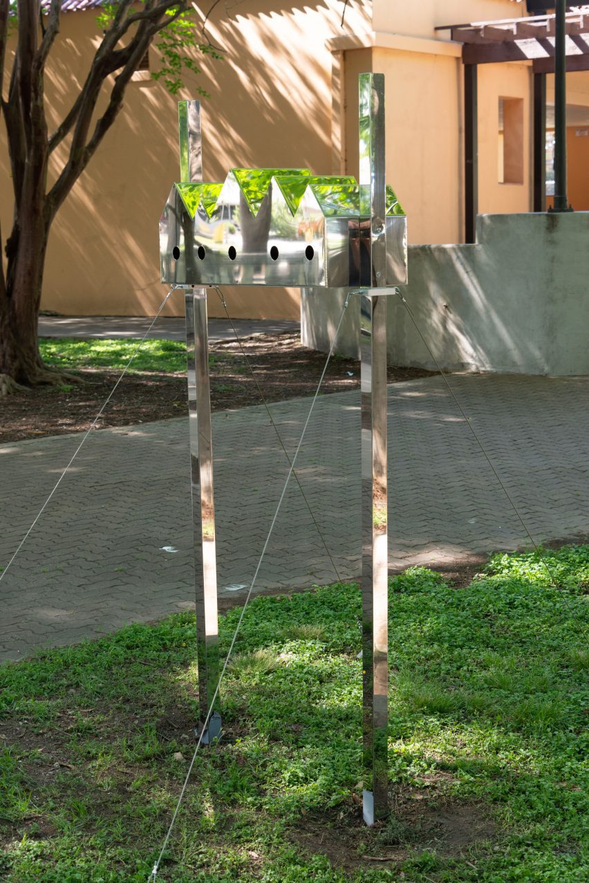 A birdhouse with a series of pitched roofs and reflective surfaces