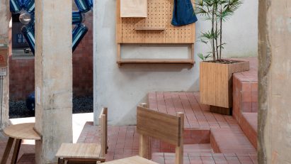 Chairs balanced on step with two front legs with peg notice board hooked over wall