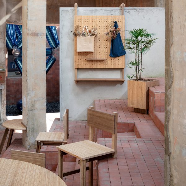Chairs balanced on step with two front legs with peg notice board hooked over wall
